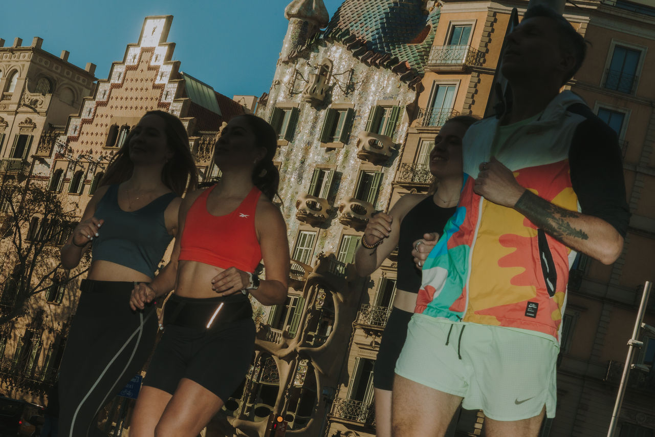 Cuatro personas corren frente a las fachadas modernistas de la Casa Amatller y la Casa Batlló.